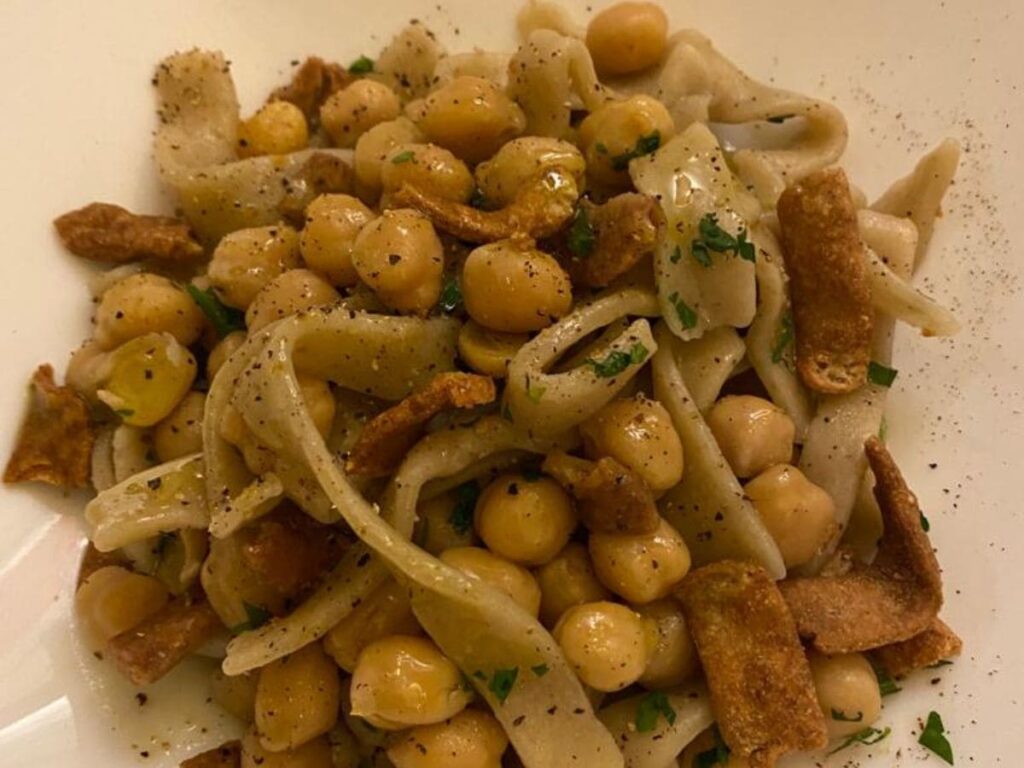 Ciciri e tria: servita con ceci morbidi e pezzi di pasta fritta croccante, che creano un piacevole contrasto di consistenze.